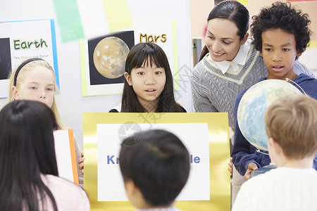 国际学校班级的小学生举着公告女孩们高清图片素材