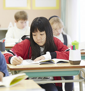 国际学校课堂上写字的学生学校层面高清图片素材