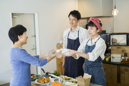 上半身冠鸦出售卖午餐盒食物事务的已婚夫妇图片