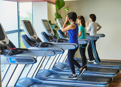 快乐的运动俱乐部苗条在健身房锻炼的妇女图片