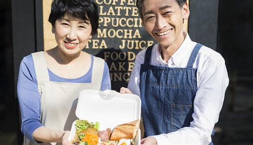 情侣售货员店员卖午餐盒食物事务的已婚夫妇图片