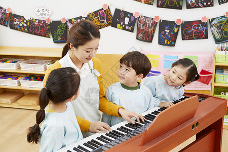 幼儿园老师教小朋友弹钢琴成年女子高清图片素材