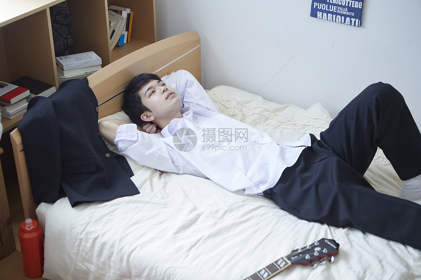 日式制服的学生仰躺在床上图片