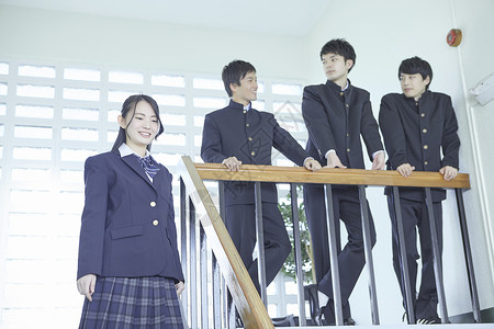 日式制服的学生靠在楼梯扶手上聊天男人高清图片素材