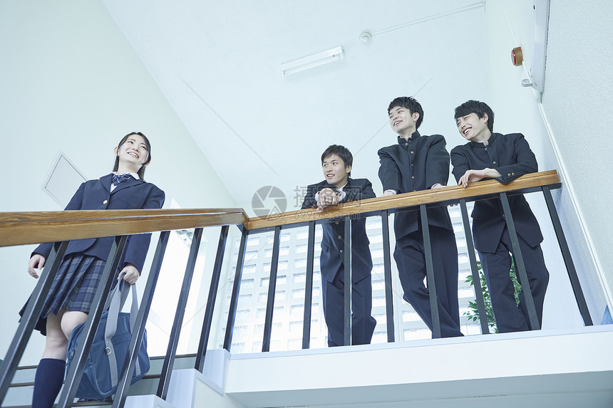日式制服的学生靠在楼梯扶手上聊天图片