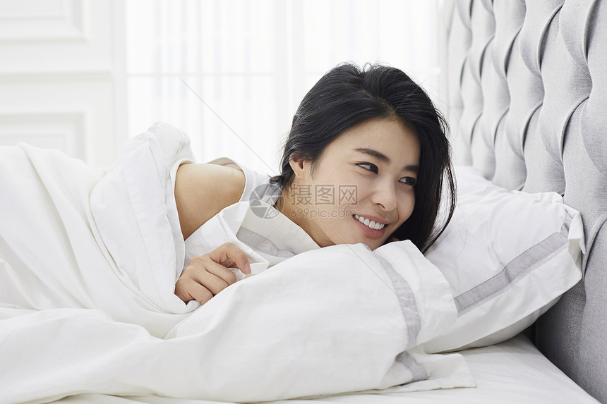 躺在床上休息开心的女青年图片