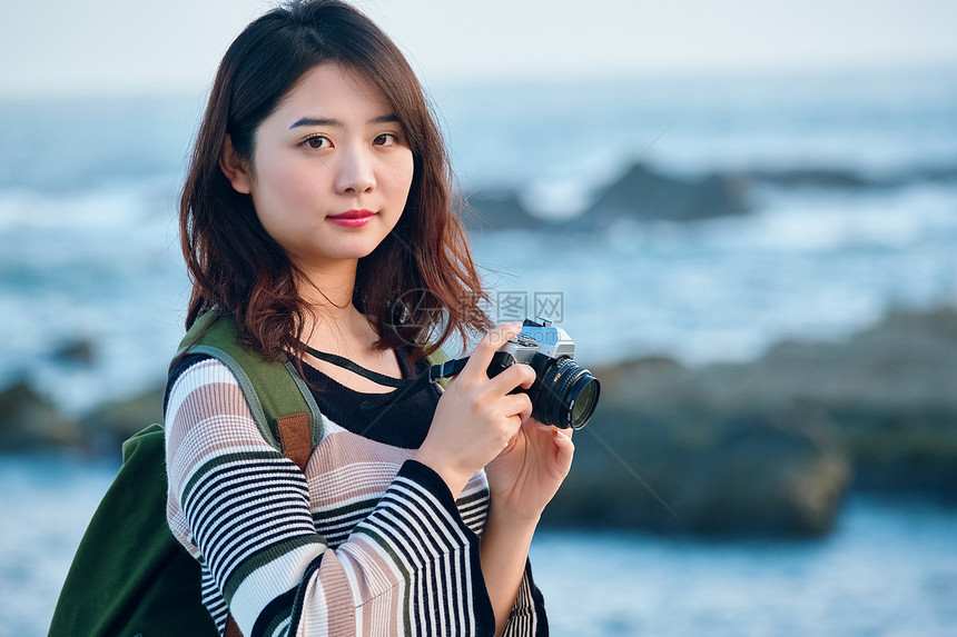 女人独自在海边旅行拍照图片