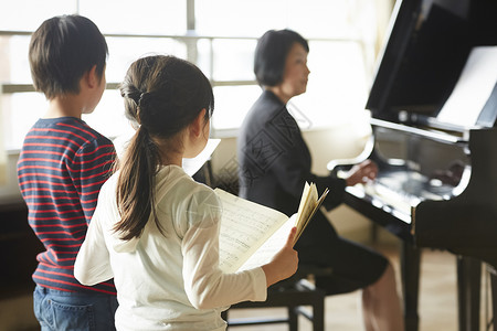 演奏钢琴男生音乐室的老师和学生背景