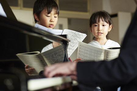 演奏钢琴男生孩子们在音乐室里唱歌背景