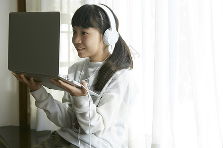音乐鉴赏论文戴着耳机线上学习的小女孩背景
