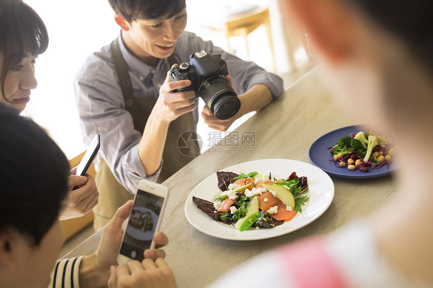 欣赏照相机摄影拍摄食物的男女图片
