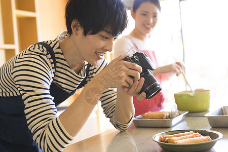 男子用相机拍照食物图片