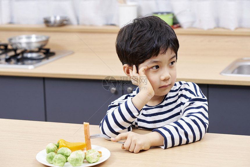 拿着叉子吃胡萝卜的小男孩图片