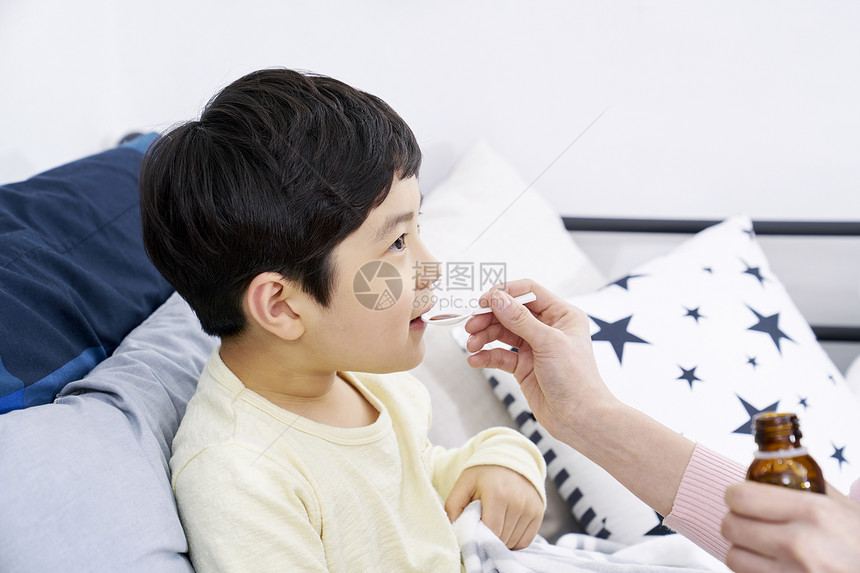 妈妈照顾生病的小男孩吃药图片
