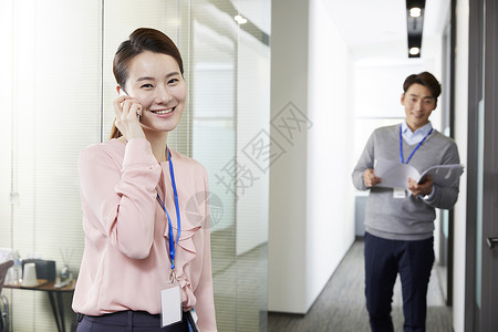 企业男职员看着女职员打电话图片