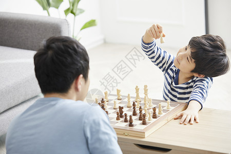 客厅里下棋拿着象棋的小男孩图片