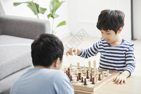 客厅里和父亲下象棋的小男孩图片
