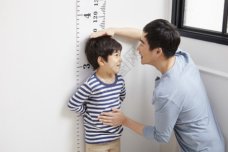 测量儿子身高的父亲图片