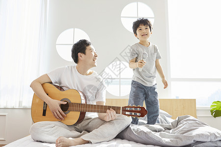 床上演奏唱歌的父子图片