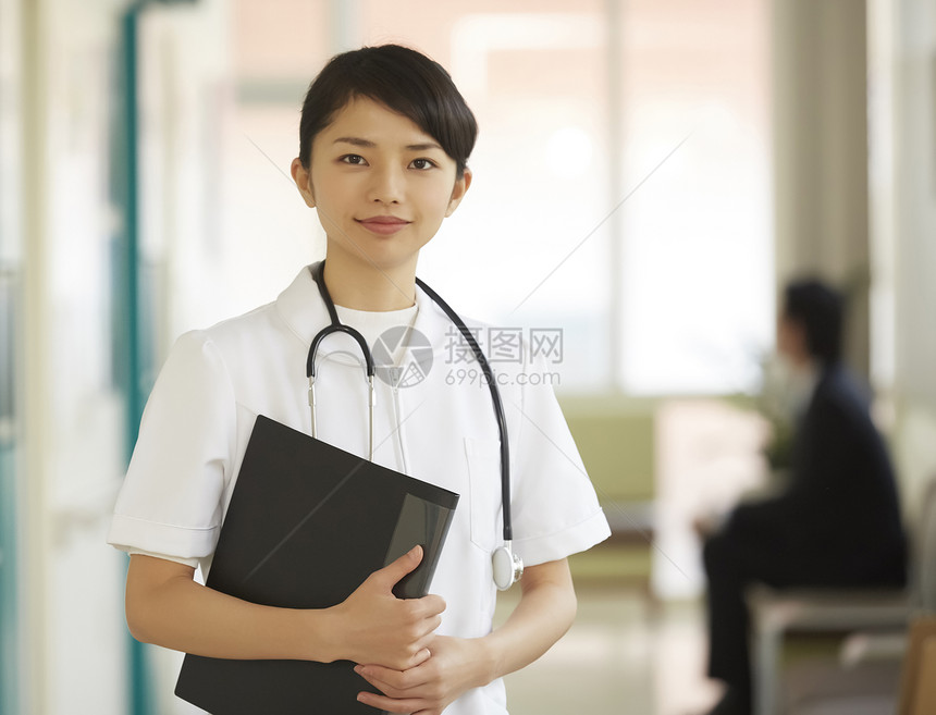 走廊里拿着医疗文件微笑的护士形象图片