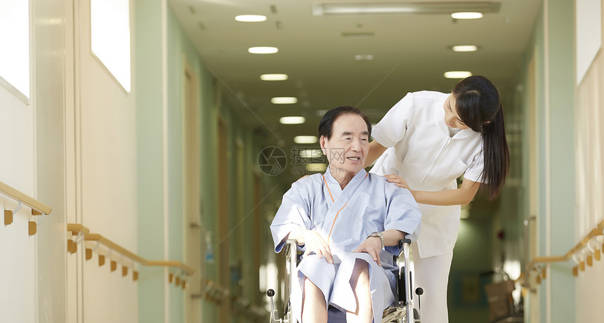 护士关切问候坐轮椅的老人图片