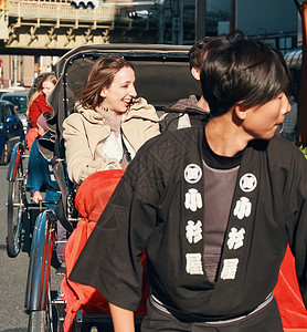 在东京旅游的外国乘客乘坐人力车微笑高清图片素材
