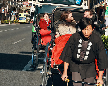 在东京旅游的外国游客乘坐人力车笑容高清图片素材