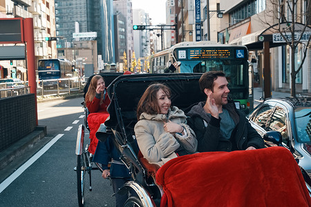 在东京旅游的外国游客乘坐人力车风景名胜高清图片素材