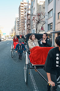 在东京旅游的外国游客乘坐人力车游览高清图片素材