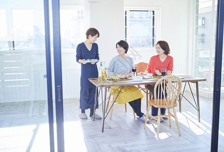 时髦女人和朋友一起吃饭家居派对高清图片素材