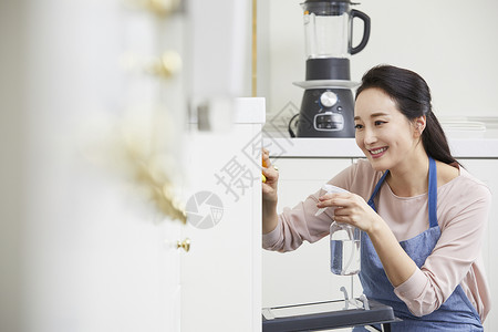 青年女性拿着喷雾清洁厨房图片