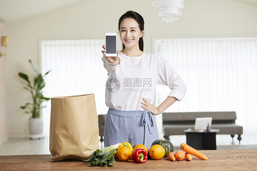 成年女子举着手机微笑图片