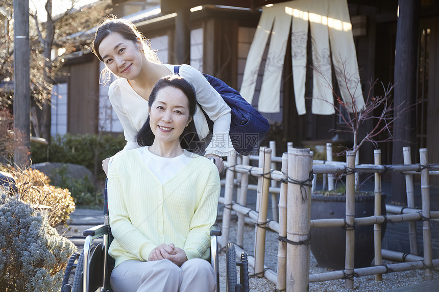 女儿推着轮椅上的妈妈户外散心图片