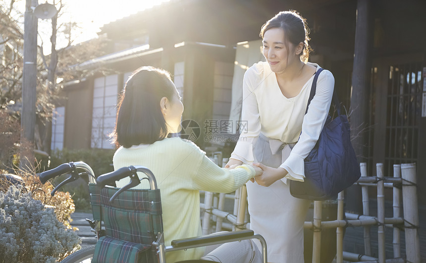 女儿推着轮椅上的妈妈户外散心图片