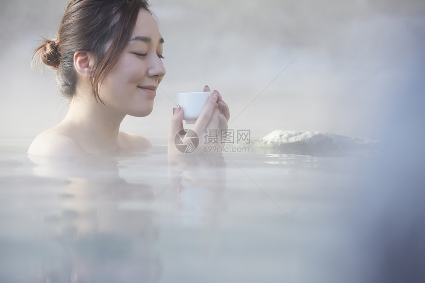女人露天泡温泉喝茶图片