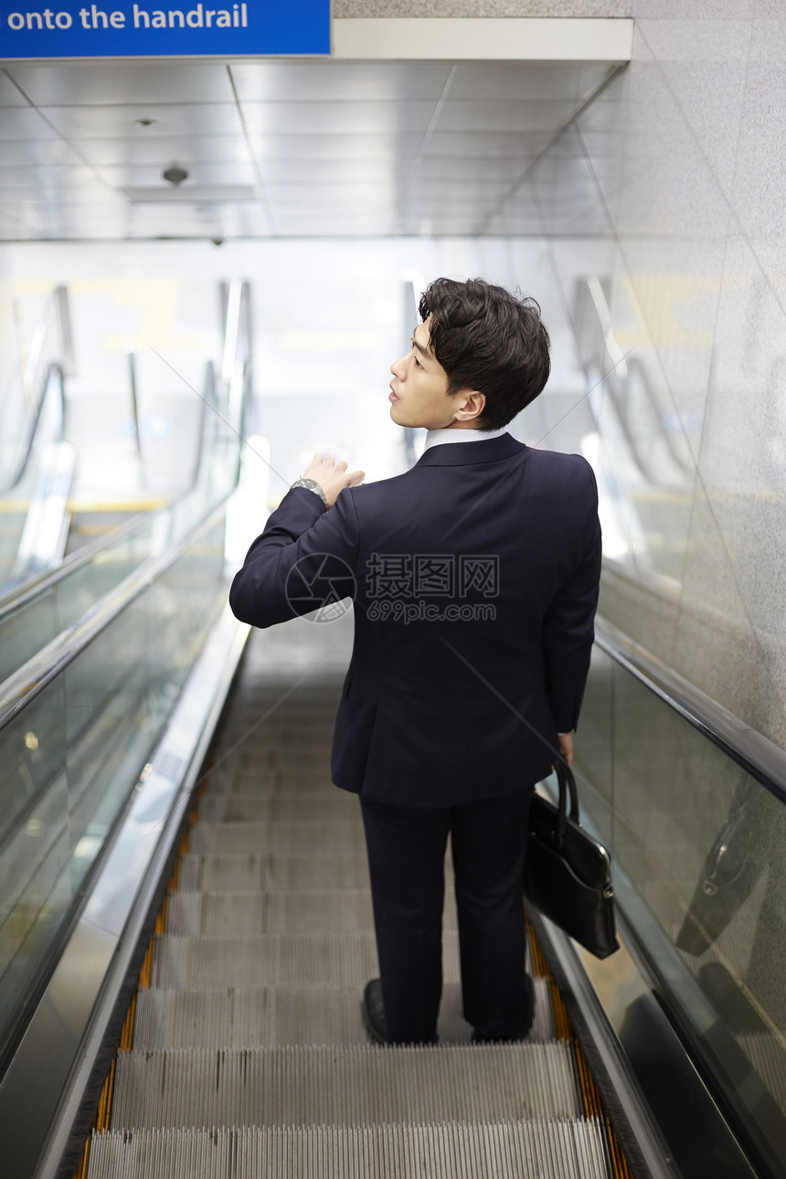 乘坐手扶电梯通勤的商务男士图片