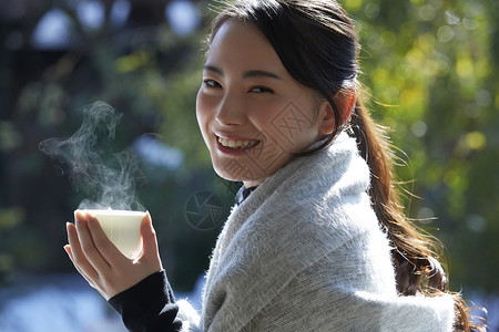 年轻女孩秋冬保暖捧着热茶图片