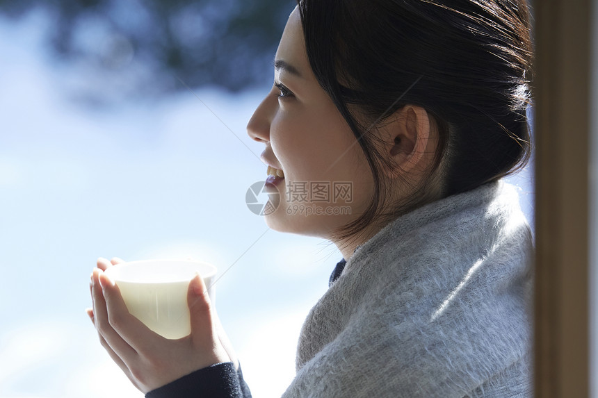 年轻女孩秋冬保暖捧着热茶图片