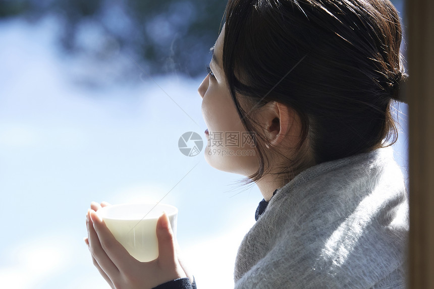 年轻女孩秋冬保暖捧着热茶图片