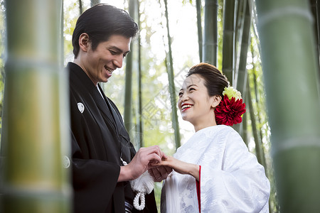 交换戒指微笑的日本礼服婚礼新娘和新郎图片
