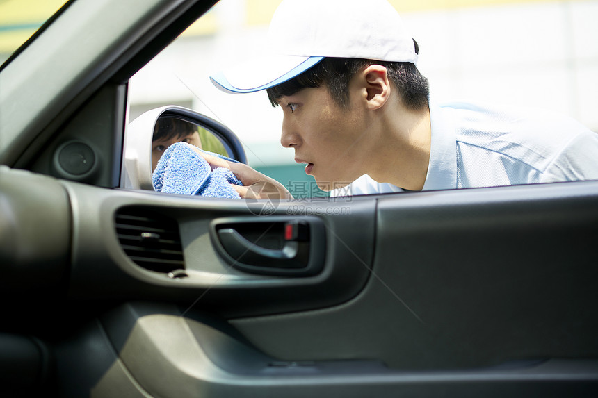 户外兼职洗车的男子图片