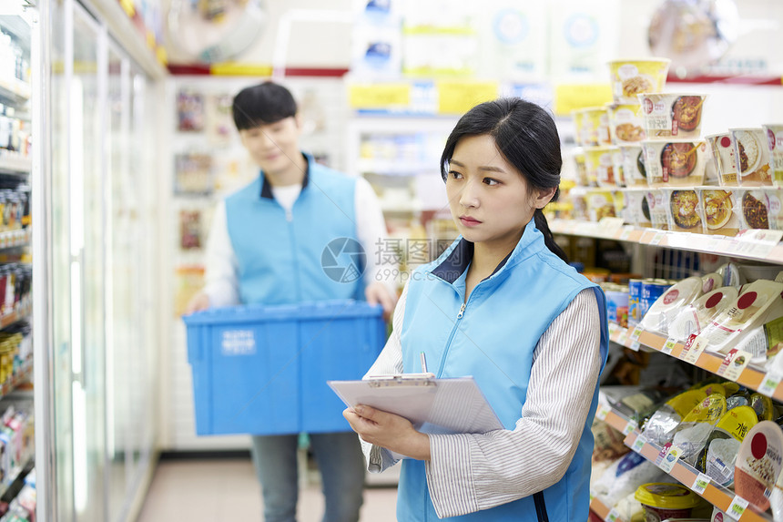 便利店年轻女子拿着文件视察图片