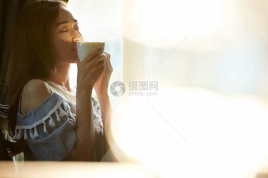 居家喝咖啡放松的年轻女子图片