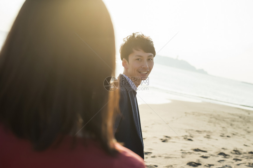 女孩休假日落夫妻海岸图片