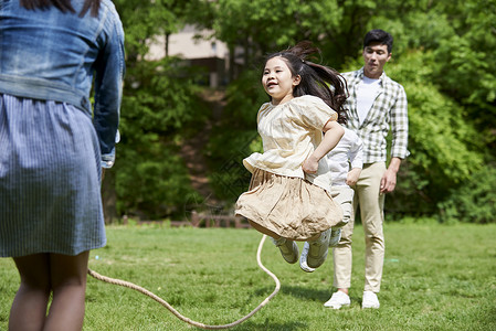 玩跳绳女孩一家四口公园跳绳背景