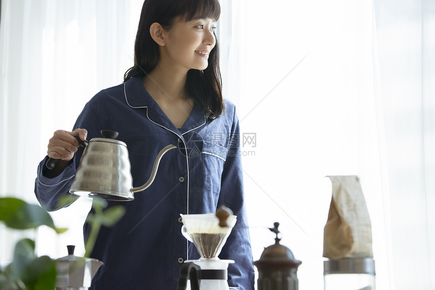 居家拿着水壶冲泡咖啡的年轻女子图片
