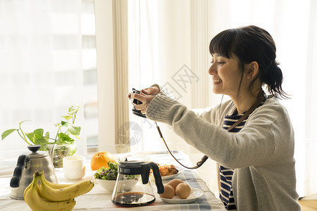 年轻女子拍摄食物照片图片