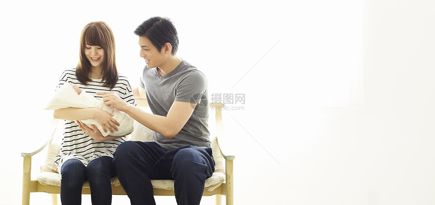 年轻夫妻抚养婴儿图片