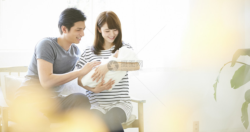 年轻夫妇在照看初生婴儿图片