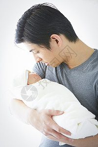 照顾婴儿的年轻父亲图片